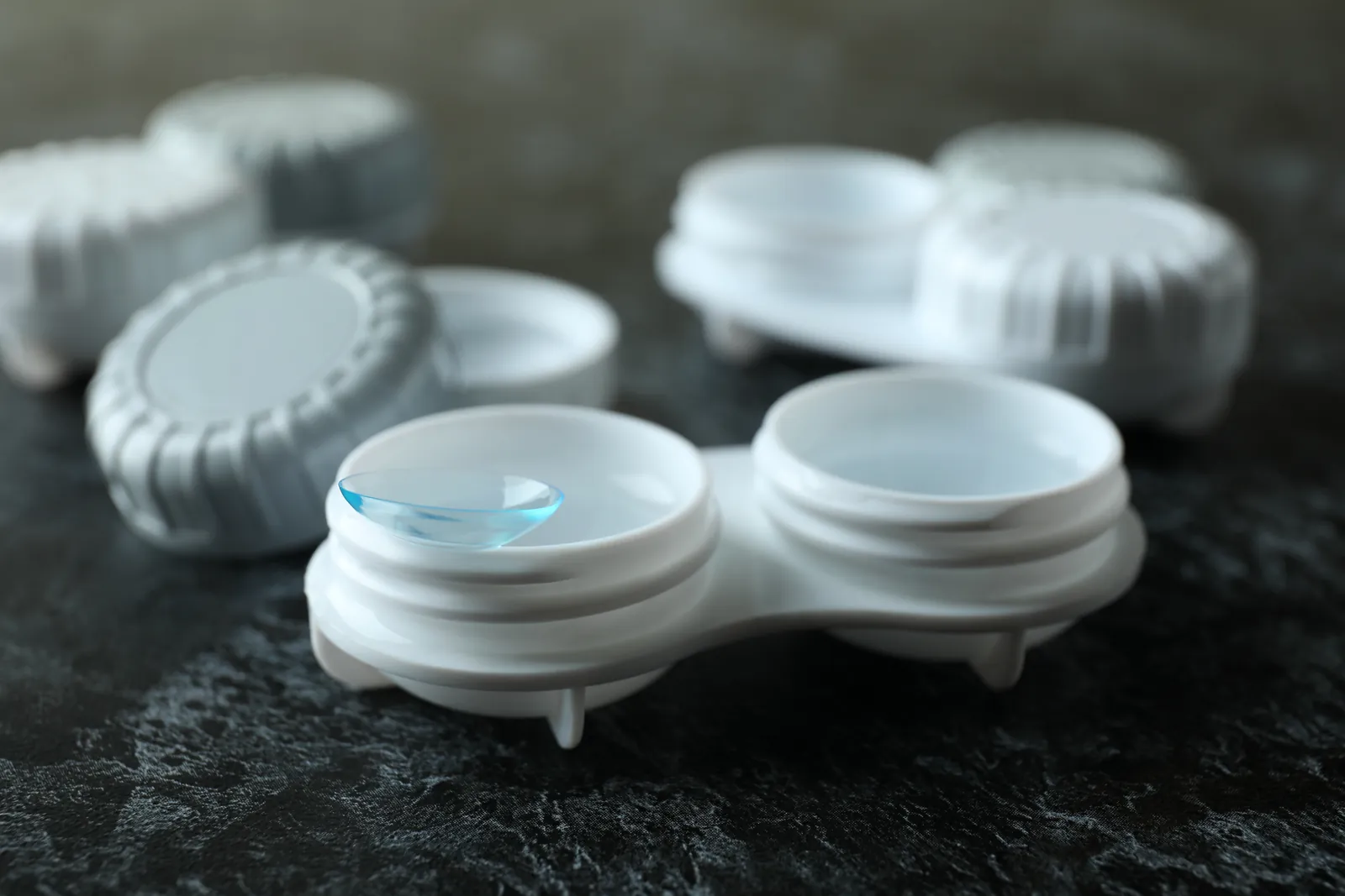 Contact lens cases with a lens resting on the rim